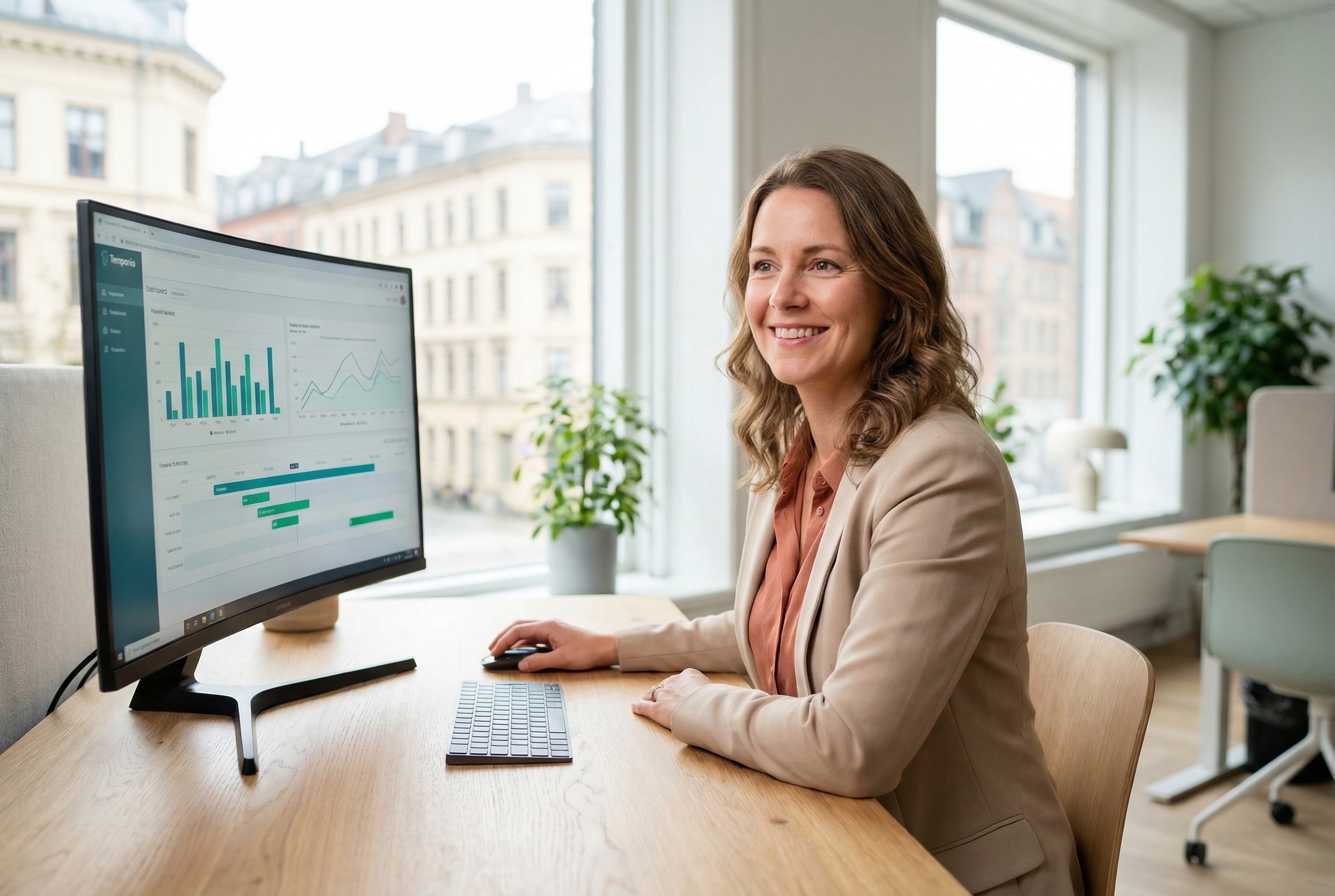 Manager reviewing time tracking analytics and dashboard reports on a monitor in a modern office